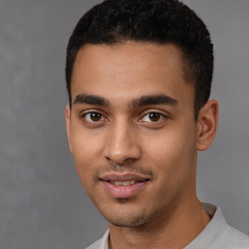 Joyful latino young-adult male with short  black hair and brown eyes