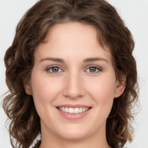 Joyful white young-adult female with medium  brown hair and green eyes