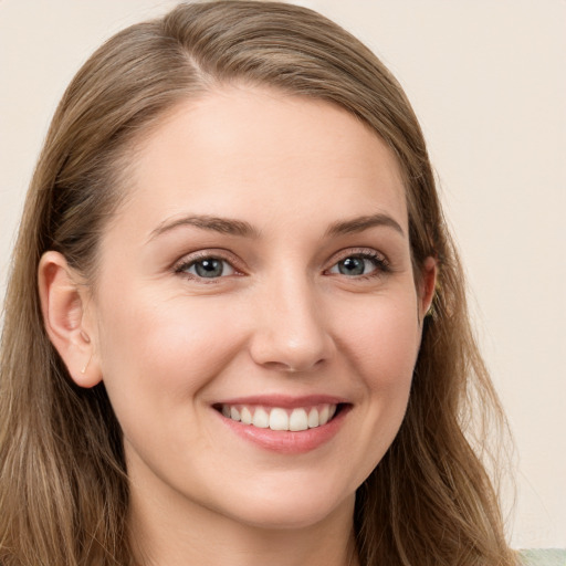 Joyful white young-adult female with long  brown hair and blue eyes