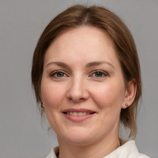 Joyful white adult female with medium  brown hair and grey eyes