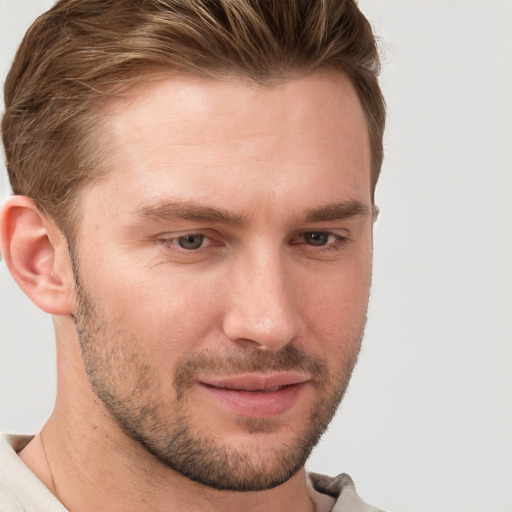 Joyful white young-adult male with short  brown hair and grey eyes