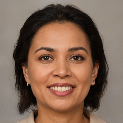 Joyful latino adult female with medium  brown hair and brown eyes