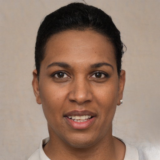 Joyful black young-adult female with short  black hair and brown eyes