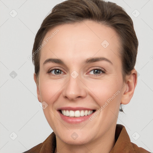 Joyful white young-adult female with short  brown hair and grey eyes