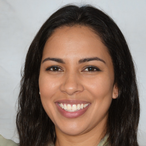 Joyful latino young-adult female with long  brown hair and brown eyes