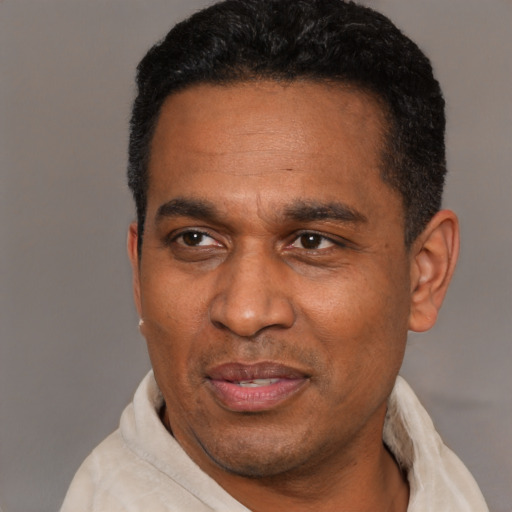 Joyful latino adult male with short  black hair and brown eyes