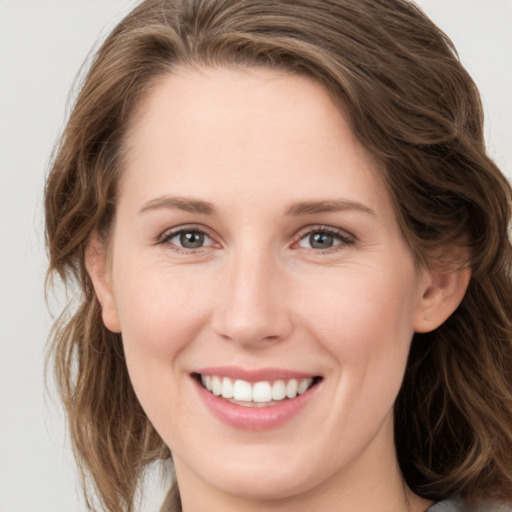 Joyful white young-adult female with long  brown hair and grey eyes