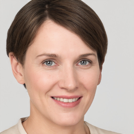 Joyful white young-adult female with short  brown hair and grey eyes