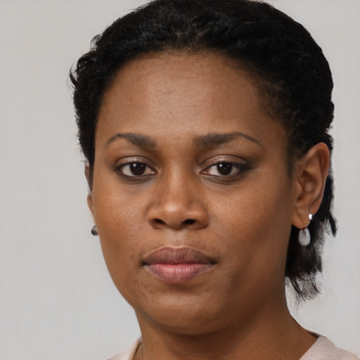 Joyful black young-adult female with short  black hair and brown eyes