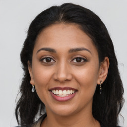 Joyful latino young-adult female with long  brown hair and brown eyes