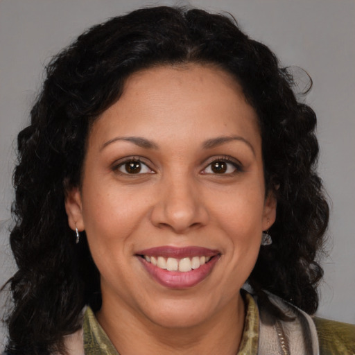 Joyful latino adult female with medium  brown hair and brown eyes