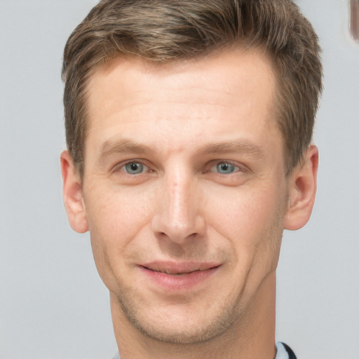 Joyful white young-adult male with short  brown hair and grey eyes