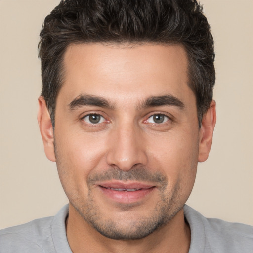 Joyful white young-adult male with short  brown hair and brown eyes