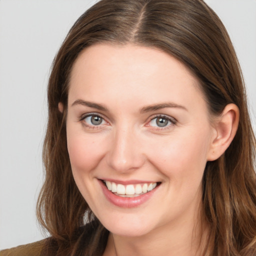 Joyful white young-adult female with long  brown hair and blue eyes