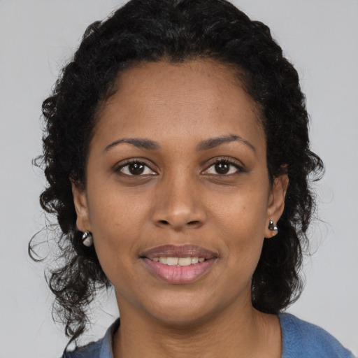 Joyful black adult female with medium  black hair and brown eyes