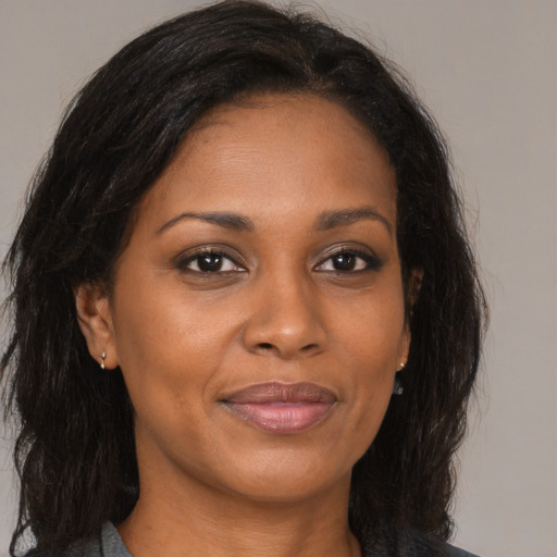 Joyful black adult female with medium  brown hair and brown eyes