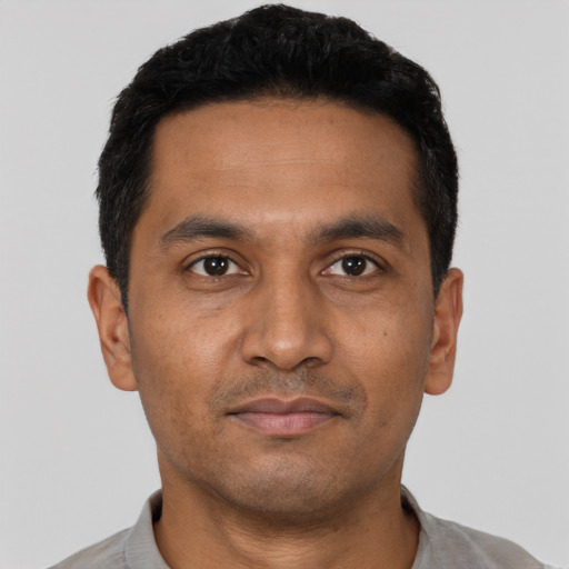 Joyful latino adult male with short  black hair and brown eyes