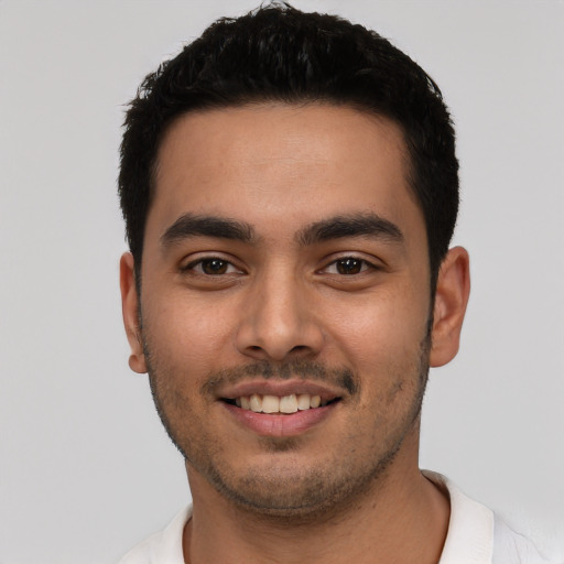 Joyful latino young-adult male with short  black hair and brown eyes