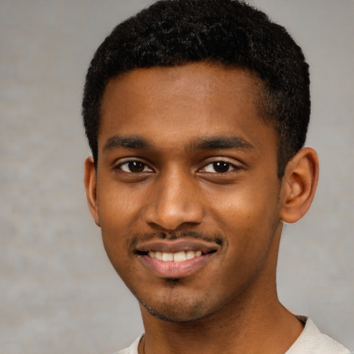 Joyful black young-adult male with short  black hair and brown eyes