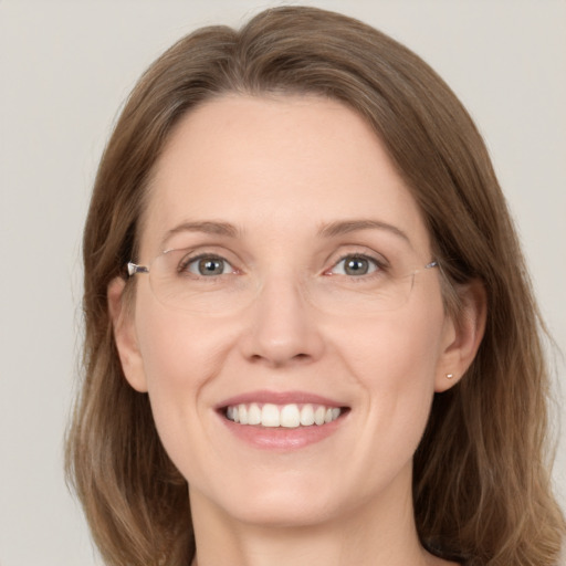 Joyful white adult female with medium  brown hair and green eyes