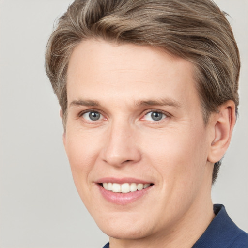 Joyful white adult male with short  brown hair and grey eyes