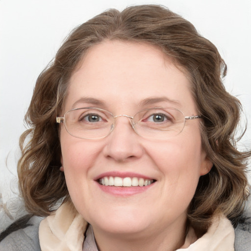 Joyful white adult female with medium  brown hair and blue eyes