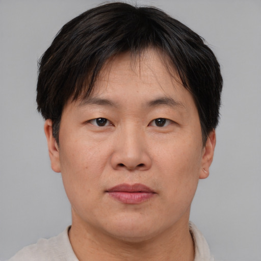 Joyful asian adult male with short  brown hair and brown eyes