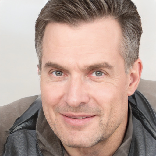 Joyful white adult male with short  brown hair and grey eyes