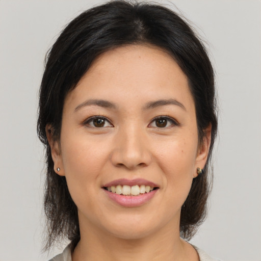 Joyful asian young-adult female with medium  brown hair and brown eyes