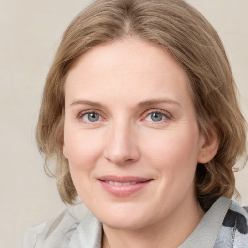 Joyful white young-adult female with medium  brown hair and blue eyes