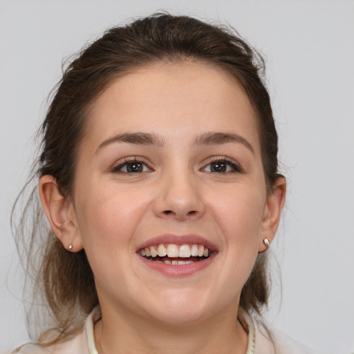 Joyful white young-adult female with medium  brown hair and grey eyes