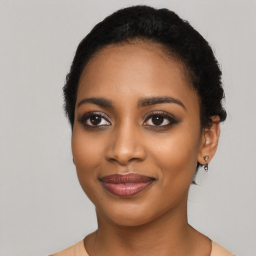 Joyful black young-adult female with long  black hair and brown eyes