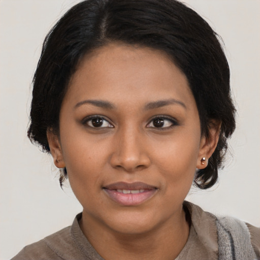 Joyful black young-adult female with medium  brown hair and brown eyes