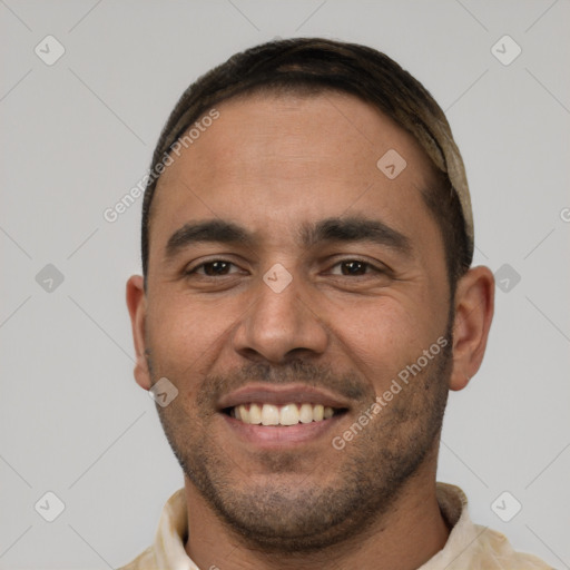 Joyful white young-adult male with short  black hair and brown eyes