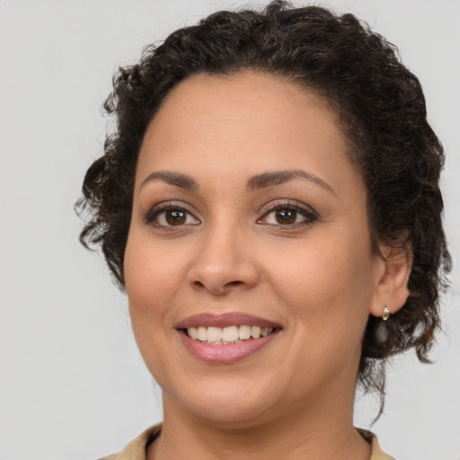 Joyful latino young-adult female with medium  brown hair and brown eyes