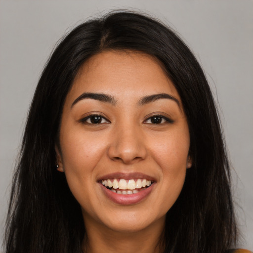 Joyful latino young-adult female with long  black hair and brown eyes