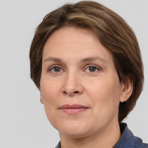 Joyful white adult female with medium  brown hair and grey eyes