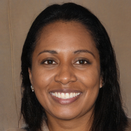 Joyful black young-adult female with long  black hair and brown eyes