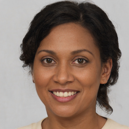 Joyful black adult female with medium  brown hair and brown eyes