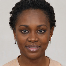 Joyful black young-adult female with short  brown hair and brown eyes