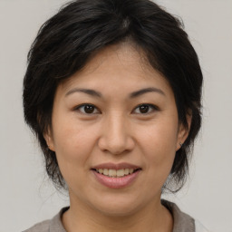 Joyful asian adult female with medium  brown hair and brown eyes