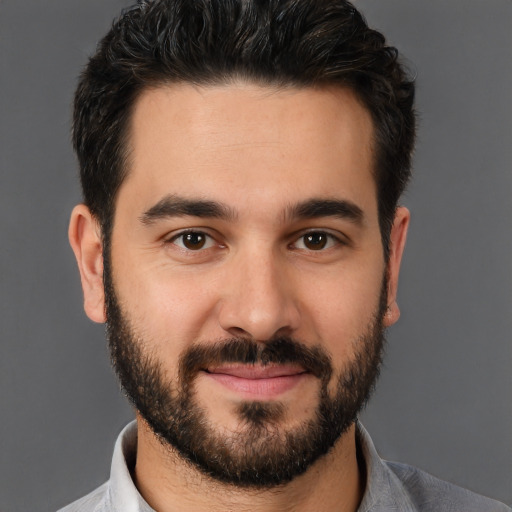 Joyful white young-adult male with short  black hair and brown eyes