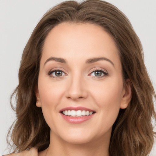 Joyful white young-adult female with long  brown hair and brown eyes