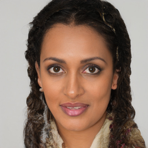 Joyful black young-adult female with long  brown hair and brown eyes