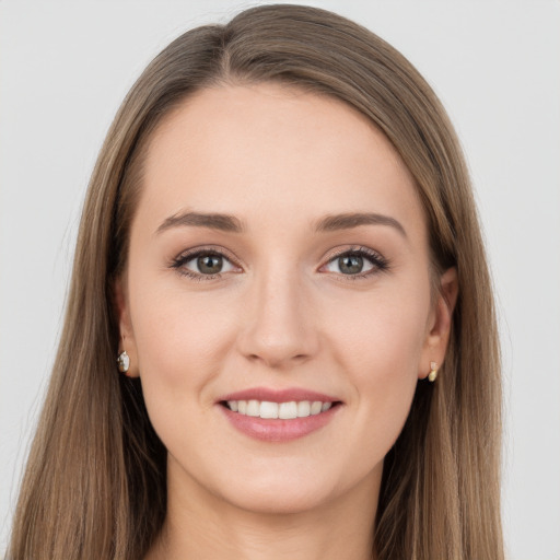 Joyful white young-adult female with long  brown hair and grey eyes