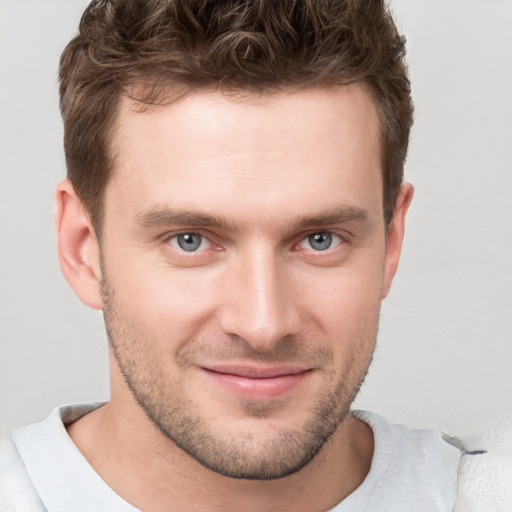 Joyful white young-adult male with short  brown hair and grey eyes