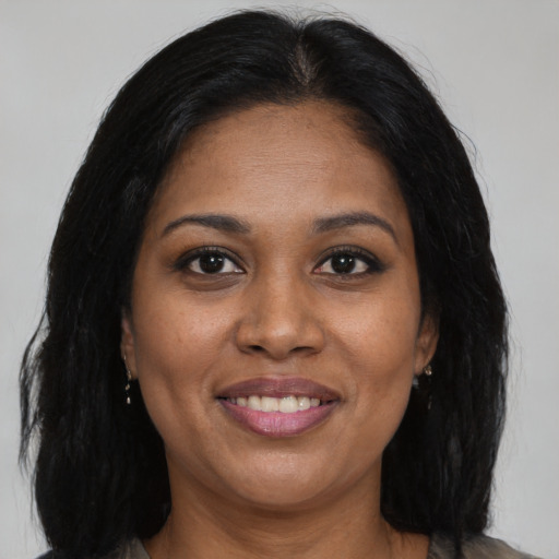 Joyful black adult female with long  brown hair and brown eyes