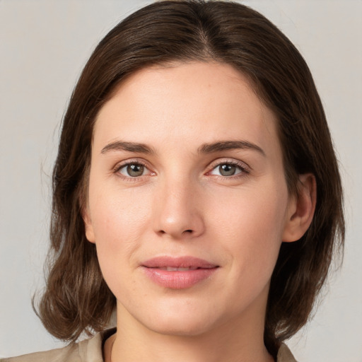 Joyful white young-adult female with medium  brown hair and green eyes