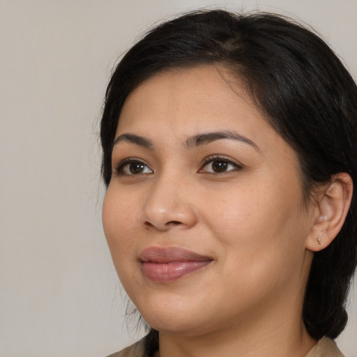 Joyful latino young-adult female with medium  brown hair and brown eyes