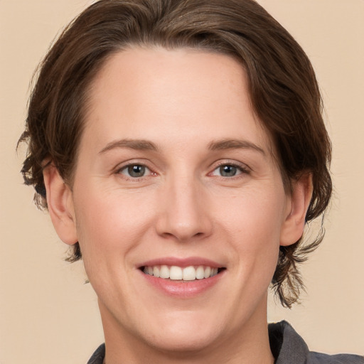 Joyful white adult female with medium  brown hair and grey eyes